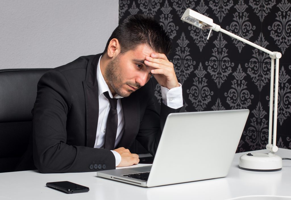 Sfrustrowany trader przed laptopem